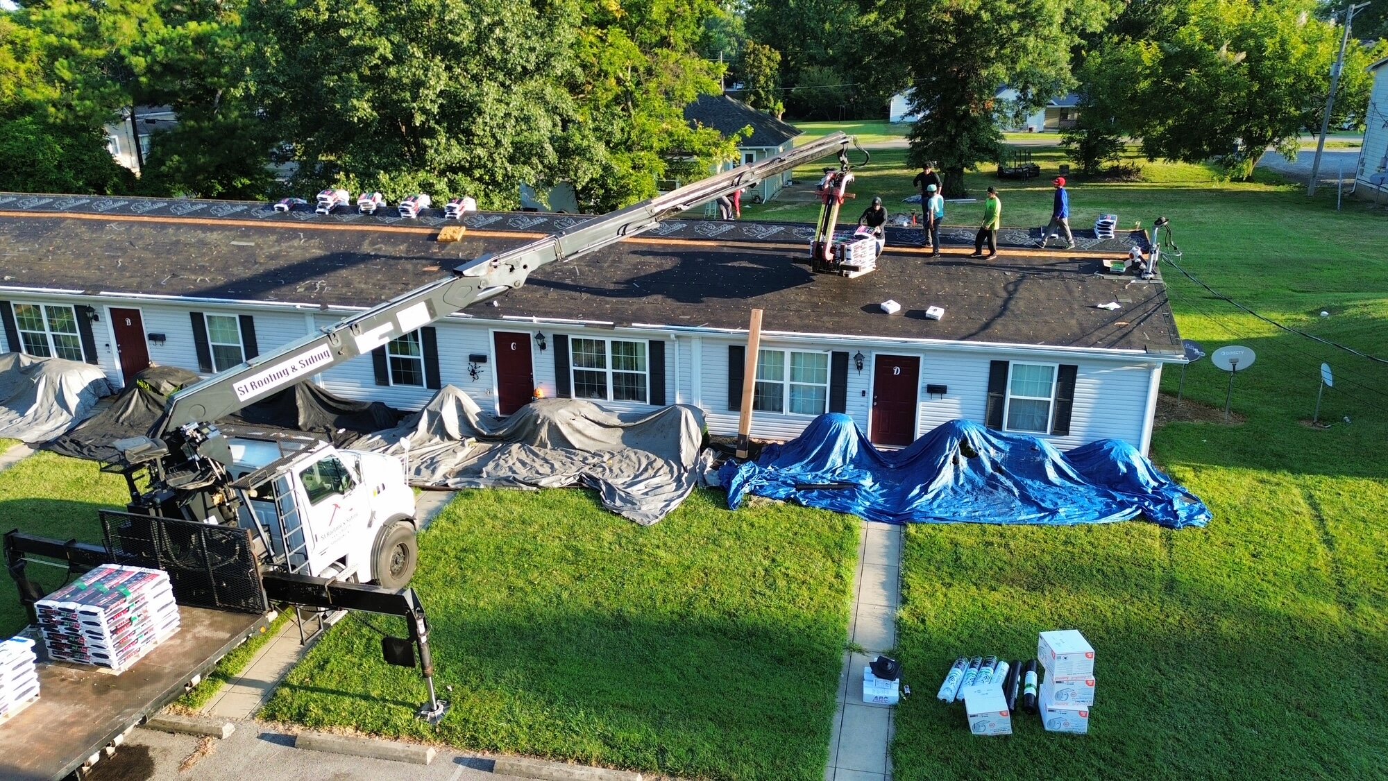 Wide aerial view of roofing work in progress